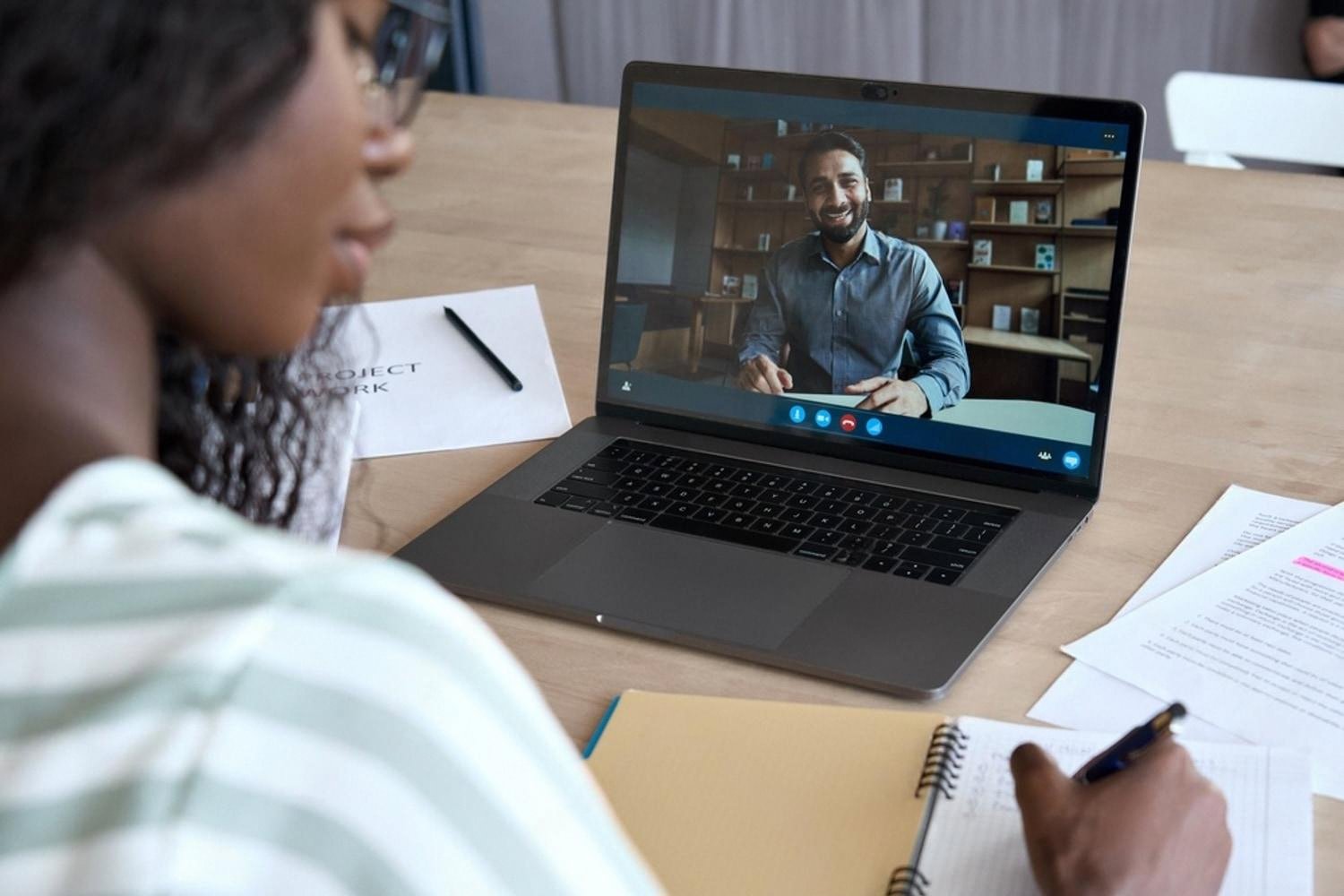 Student on a video call with a career advisor while taking notes